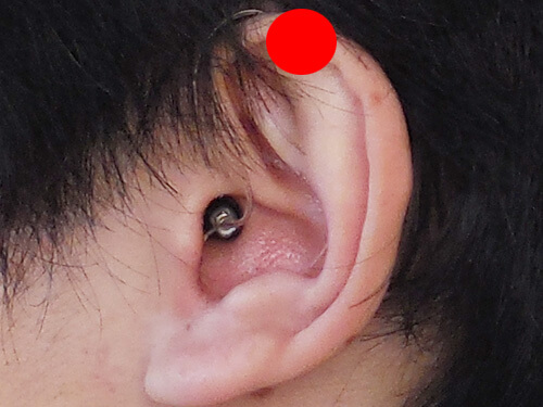 補聴器は、だいたい赤いマークの位置にあります。そのため、その部分に重なるものがあると、少し邪魔に感じやすくなります。